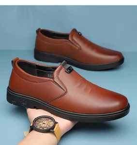 Detailed view of brown leather loafers featuring a metal logo and durable rubber sole