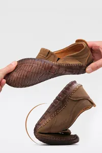 Macro view of highly flexible and soft brown leather loafer showing 180-degree foldability