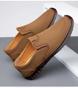 Detail view of khaki slip-on loafers featuring hand-stitched seams and embossed patterns