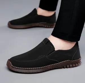 Close-up of black slip-on casual men's shoe with wave textured upper and brown rubber sole