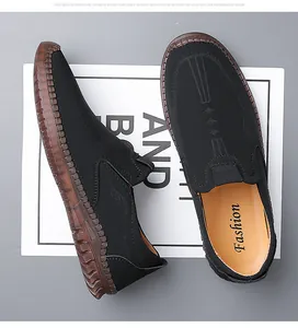 Macro view of men's black loafers with non-slip brown thick sole and decorative stitching