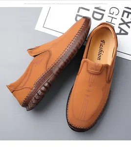 Detailed view of hand-stitched leather seams and Sport logo on brown slip-on shoes