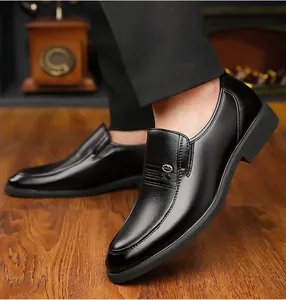 Macro shot of men's black leather slip-on shoes with side metal logo and grain texture