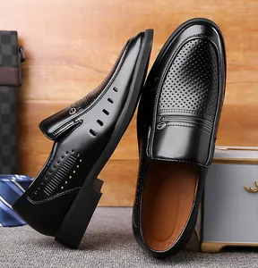 Close-up of black leather loafers featuring breathable laser-cut holes and metal buckle