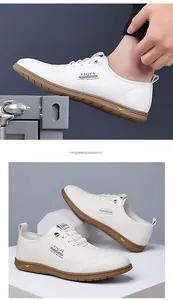 Detail of white casual loafers with brand logo and durable brown rubber soles for men