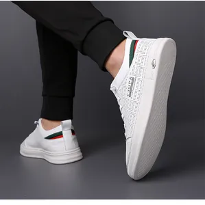 Close-up of white leather casual sneakers featuring breathable perforations and red-green stripes