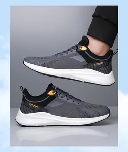 Dettaglio di scarpe da corsa in mesh grigio traspirante con accenti arancioni e suola antiscivolo