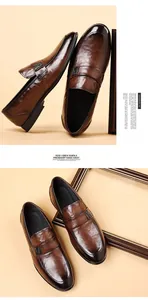 Detail of dark brown leather loafers with a metallic V-logo buckle and smooth finish