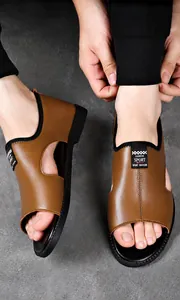 Detailansicht der braunen Leder-Herrensandalen mit seitlicher Aussparung und Sportlabel