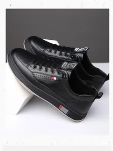 Détail de chaussures en cuir noir avec perforations respirantes et logo M distinctif