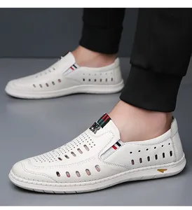 Close-up of white leather loafers with breathable cutouts and tricolor strap detail