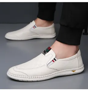 Detalle de mocasines de cuero blanco con cinta de rayas clásica y hebilla metálica