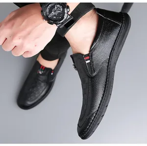 Detalle de mocasín en cuero granulado negro con cinta tejida de rayas clásicas