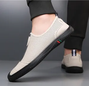 Detail of beige perforated leather slip-on shoes for men with side stripe and rubber sole