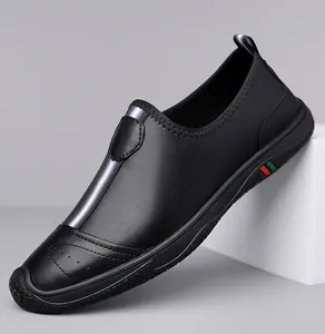 Close-up of black leather loafer showing perforated toe detail and striped side accents