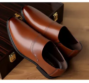Detail of brown glossy leather business loafer with fine perforated patterns and rubber sole