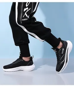 Vue latérale dynamique de baskets en mesh noir respirant avec semelles blanches à vagues