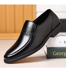 Détail de mocassins en cuir noir avec logo métallique et semelle en caoutchouc