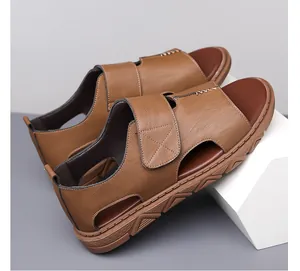 Detailopname van bruine leren herensandalen met klittenband en ademende uitsnijdingen