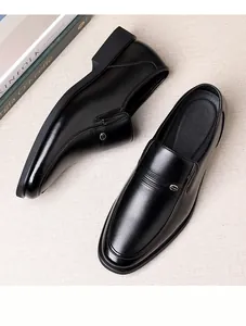 Détail de mocassin de bureau en cuir noir avec boucle en métal et fini poli