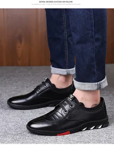Détail de chaussures homme en cuir noir avec accents géométriques rouges et blancs sur la semelle