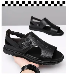 Detail of men's black leather sandals with crocodile texture and metal chain buckle