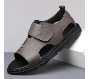 Close-up van bruine leren herensandalen met ademende uitsparingen en klittenbandsluiting