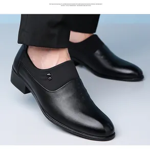 Detail of black slip-on dress shoes featuring subtle crocodile texture and metal rivets