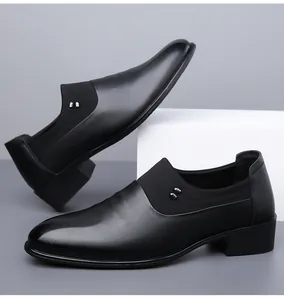 Detail of black leather business shoes with elastic side panels and twin metal buckles