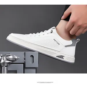 Dettaglio di sneaker bianche in pelle con trama a griglia e logo RETORI laterale