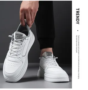 Close-up of white leather sneakers with textured rubber sole and branded tongue detail
