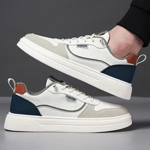 White casual leather sneakers for men with gray and blue panels and thick rubber soles