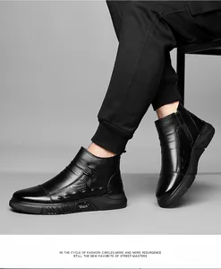 Detail of black leather boots with side zipper and crocodile pattern embossed texture