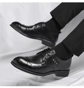 Detail von schwarzen Leder-Oxfordschuhen mit Metallnieten und dekorativem Brogue-Muster