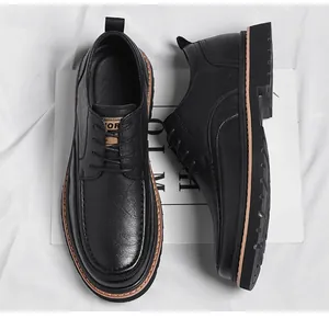 Detail view of black leather brogues showing textured grain and brown sole trim accents