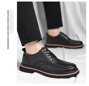 Detail of men's black brogue shoes showing fine leather texture and brown sole accents