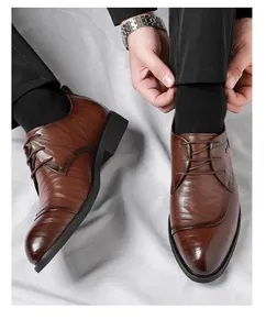 Nahaufnahme brauner Herren-Derbyschuhe mit Kappe, kombiniert mit einer Anzughose