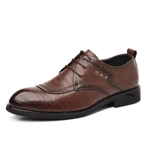 Klassische braune Leder Business-Schuhe mit spitzer Kappe und Nietendetails auf weißem Grund