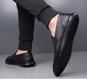 Detailed macro view of black lychee grain leather loafers with non-slip rubber soles