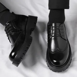 Schwarze Herrenschuhe mit dicker Sohle, Brogue-Verzierung und poliertem Leder