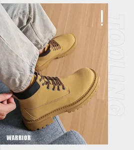 Nahaufnahme klassischer gelber Nubuk-Arbeitsstiefel mit dicken Gummisohlen auf Holzboden