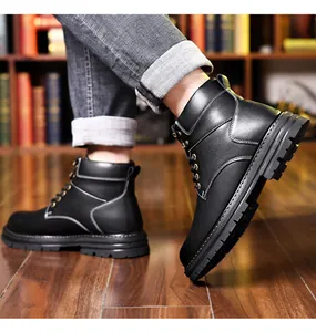Close-up of men's black winter leather boots with stitching and non-slip rubber sole