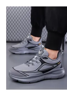 Detailed side view of gray breathable running shoes with Sport lettering on high soles