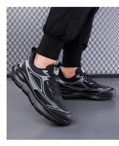 Detail view of breathable black mesh running sneakers with thick cushioned soles and sport text