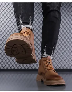 Detailed view of non-slip rubber soles on brown men's outdoor casual worker boots