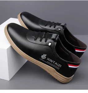 Détail de chaussures décontractées en cuir noir montrant la broderie et le ruban au talon