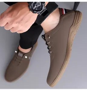 Close-up of tan leather casual shoe featuring decorative stitching and tricolor heel tab