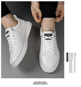 Detailed close-up of the smooth white leather texture and flat laces of the casual shoe
