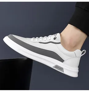 Profilo laterale di sneakers casual da uomo bianche e grigie con suole in gomma testurizzata