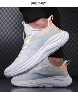 Seitenansicht der weißen Mesh-Laufschuhe mit orangen und blauen Akzenten vor Industriehintergrund